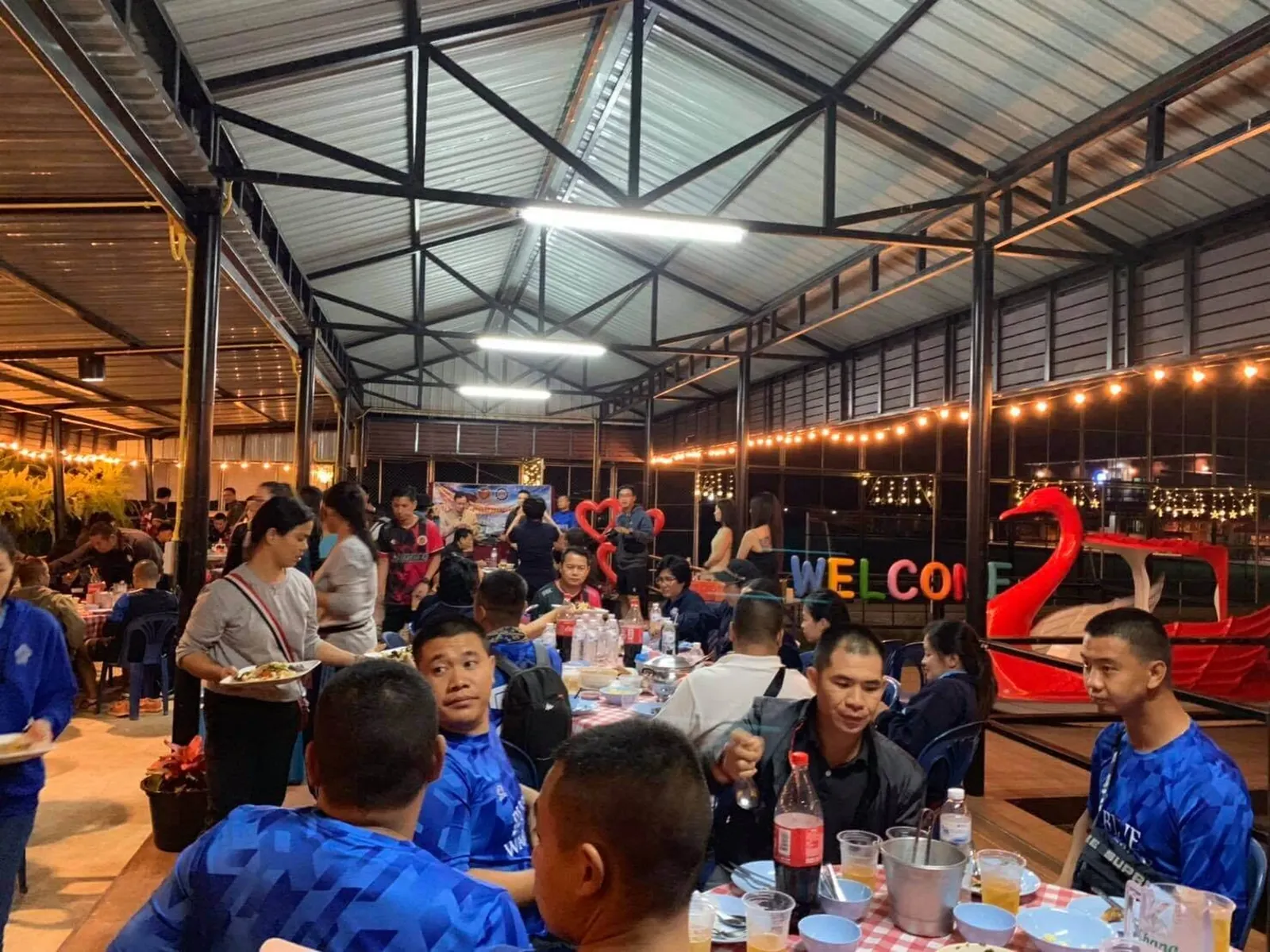 A team in blue kit eating dinner together in the open-sided restaurant