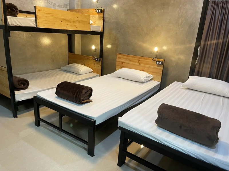 A team dormitory with single beds and a bunk, a towel folded on each bed
